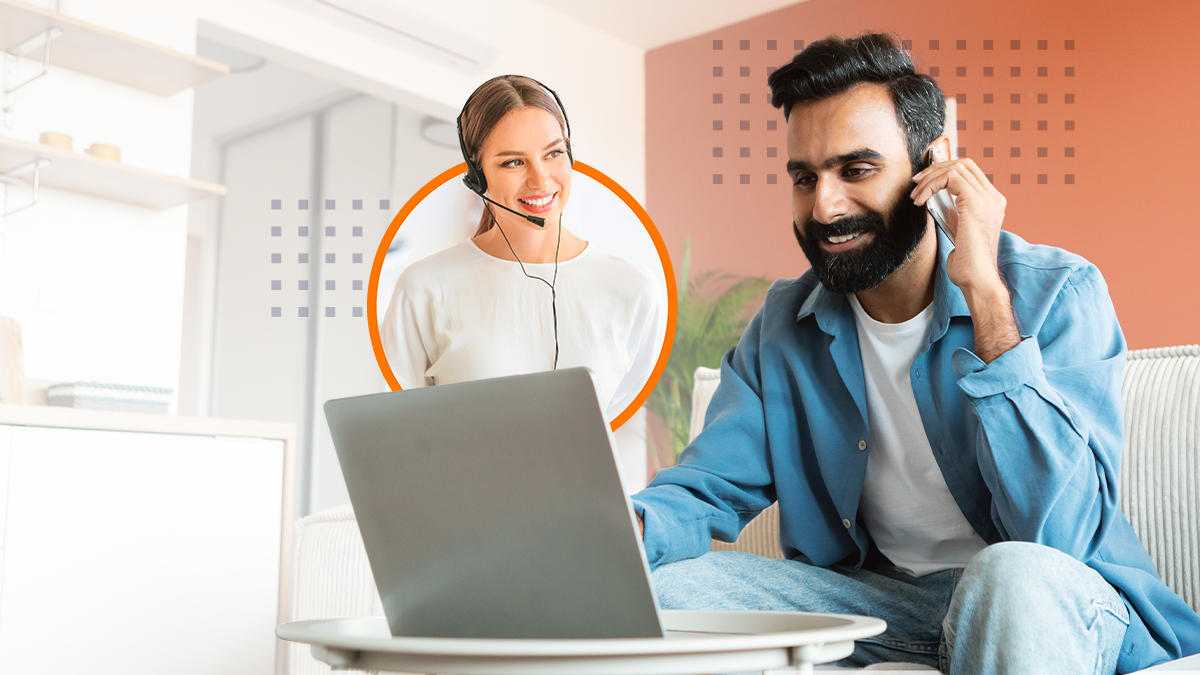 Cheerful young man having phone talk while working on the laptop