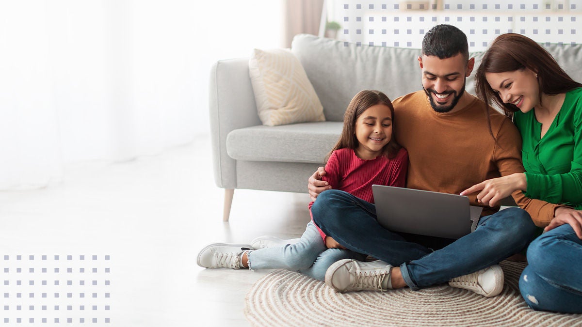 Young parents and their daughter using laptop at home