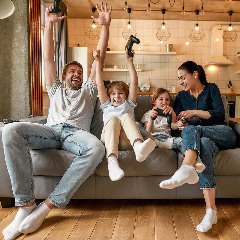 Overjoyed family with kids play video games at home