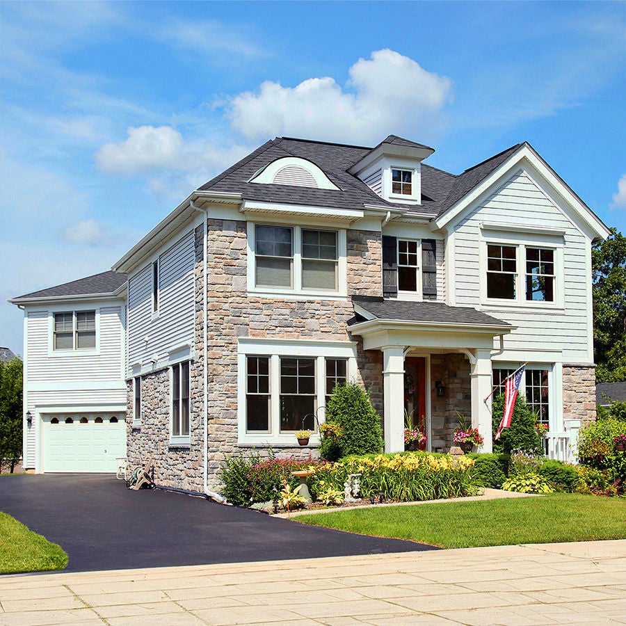 A white exterior and grey roof suburban home with front porch
