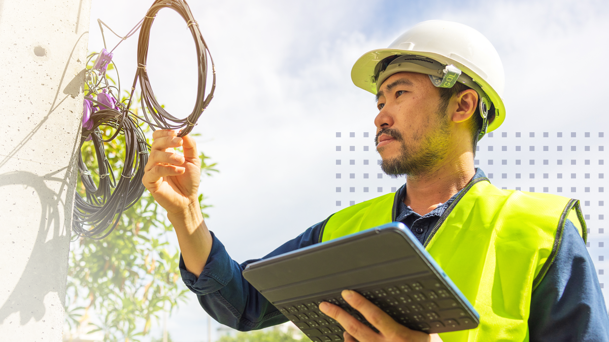 telecommunication engineer checking the optical cables holding tablet in one hand