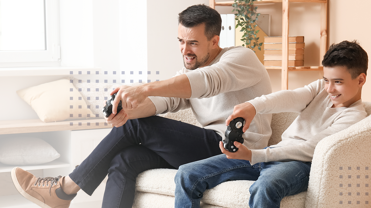 A father and son playing video games together on a couch