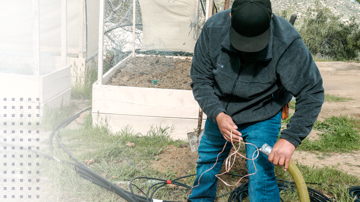 A tribal broadband employee installing wire for a network outside of a home